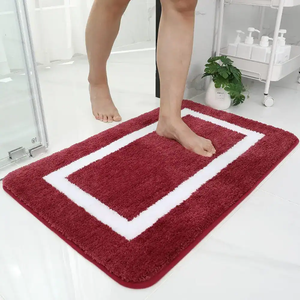Grote dikke badmat in bordeauxrood met witte rand, antislip voor badkamer.
