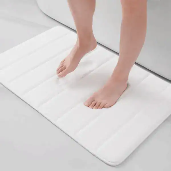 Grote witte badmat met gestikt patroon voor de badkamer.