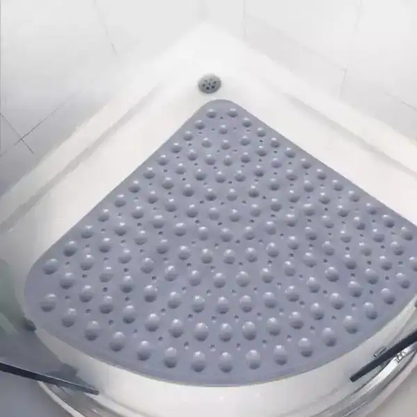 Hoek douchemat grijs met antislip bolletjes in witte douche.
