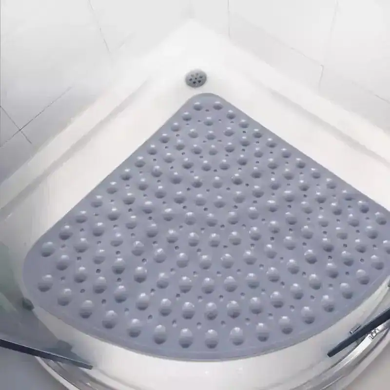 Hoek douchemat grijs met antislip bolletjes in witte douche.