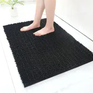 Zwarte hoogpolige badmat met antislip rand, geschikt voor badkamer en douche.