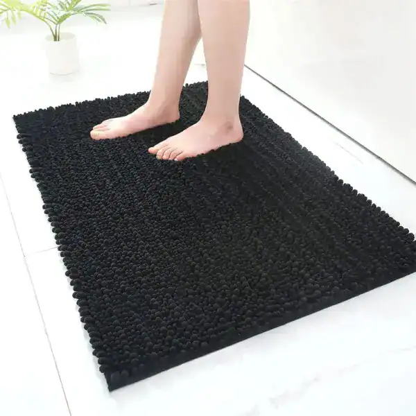 Zwarte hoogpolige badmat met antislip rand, geschikt voor badkamer en douche.