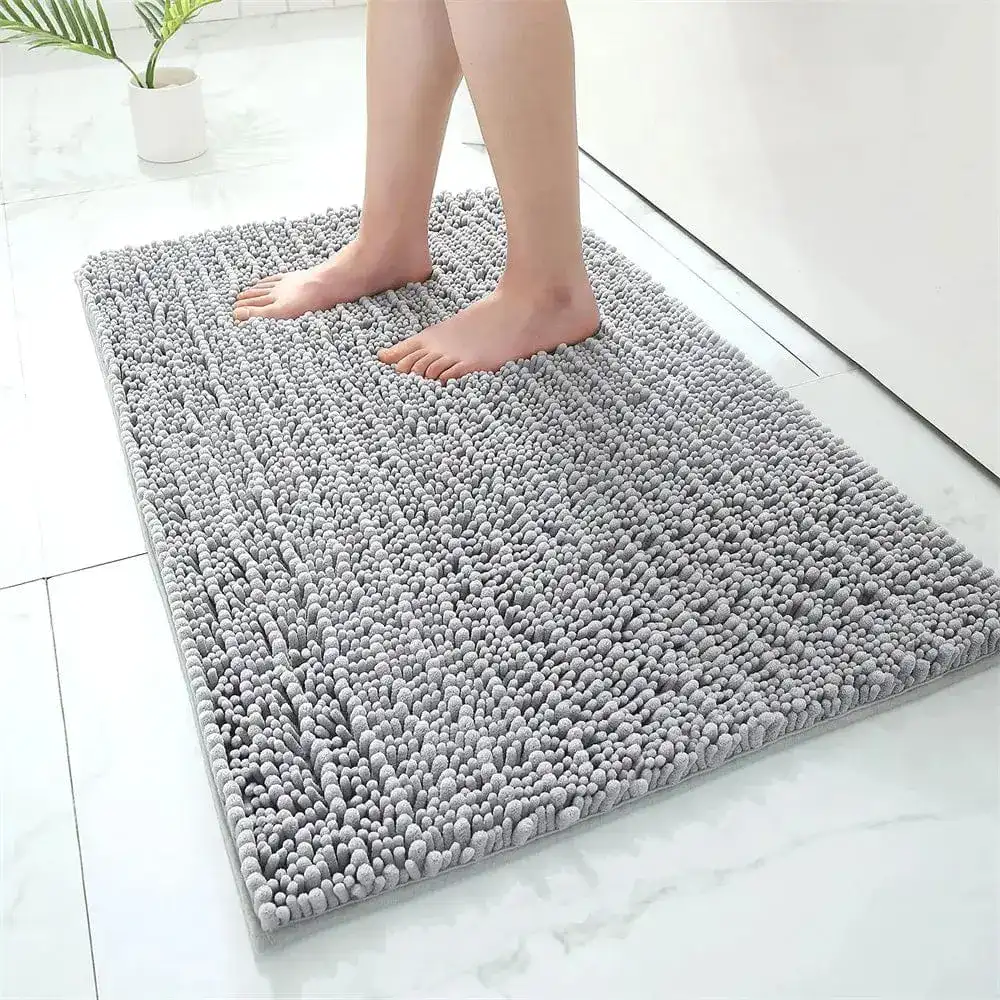 Grijze hoogpolige badmat met antislip effect in de badkamer.