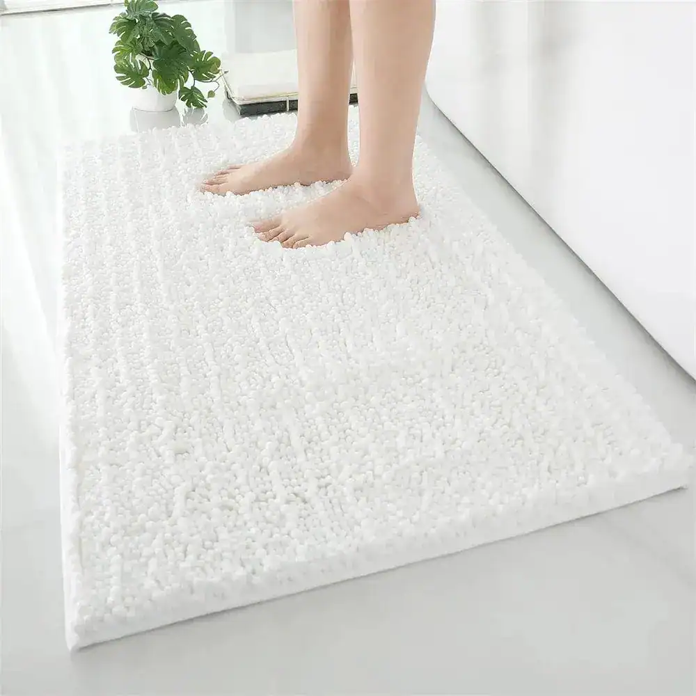 Wit hoogpolige badmat in badkamer met antislip eigenschappen.