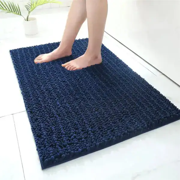 Donkerblauwe hoogpolige badmat met antislip effect in een moderne badkamer.