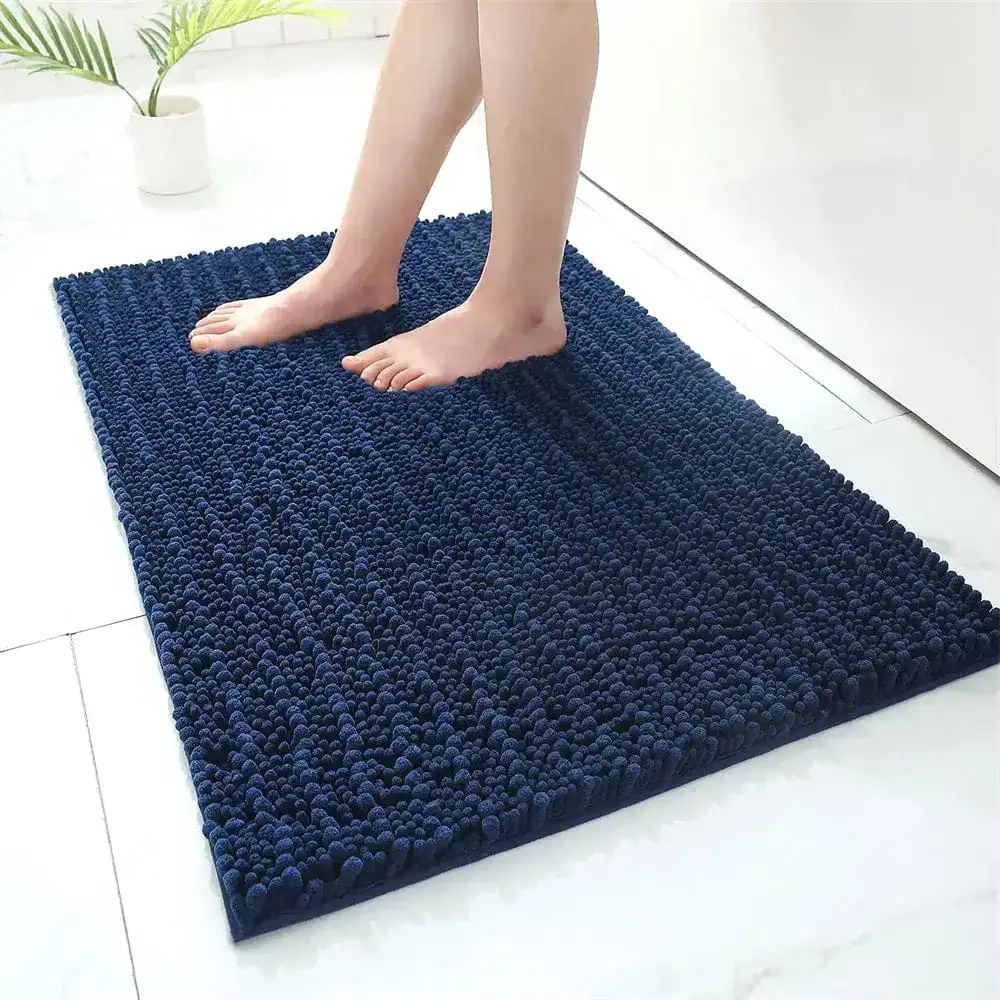 Donkerblauwe hoogpolige badmat met antislip effect in een moderne badkamer.