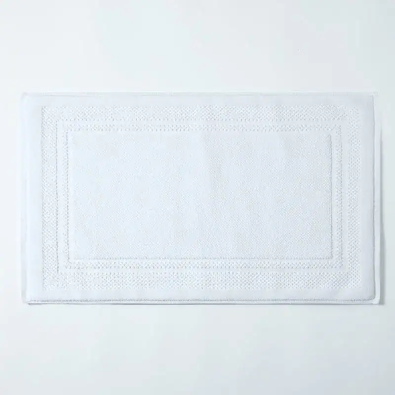 Witte katoen badmat met geborduurde rand, antislip badkamermat.