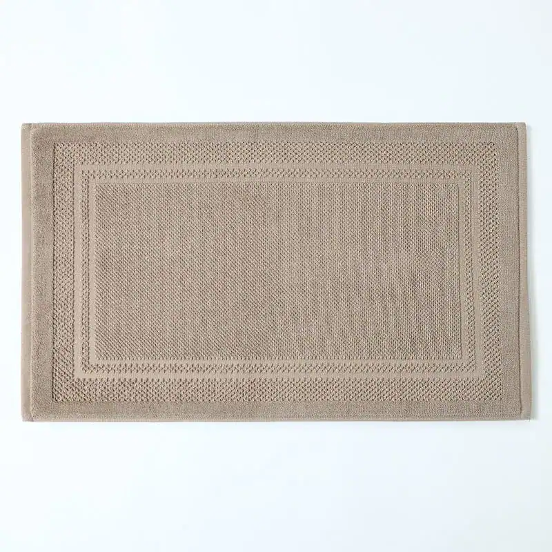 Beige katoen badmat met gestreepte rand, antislip badkamermat.