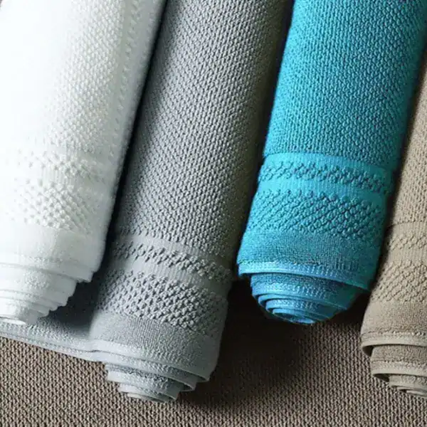 Katoen badmat in verschillende kleuren, opgerold en klaar voor gebruik in de badkamer.