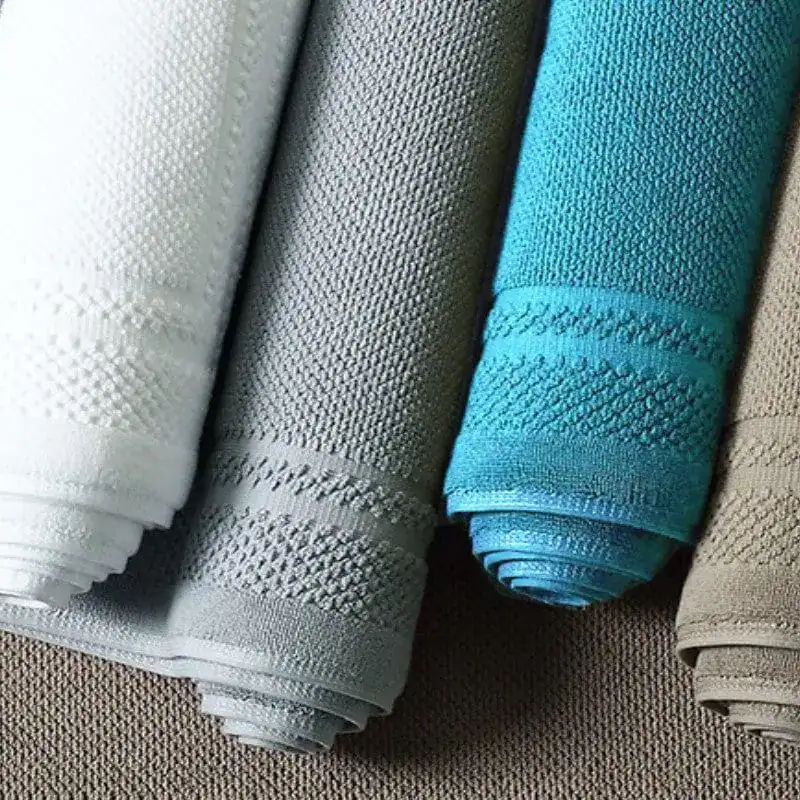 Katoen badmat in verschillende kleuren, opgerold en klaar voor gebruik in de badkamer.