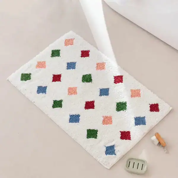 Kleurrijke badmat met roze groene en blauwe vierkanten op witte achtergrond.