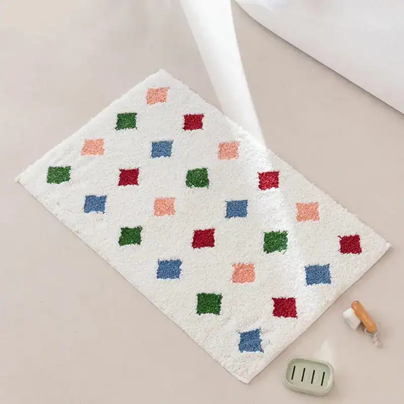 Kleurrijke badmat met roze groene en blauwe vierkanten op witte achtergrond.