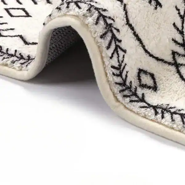 Lange smalle badmat met zwart-wit geometrisch patroon en antislip onderkant.