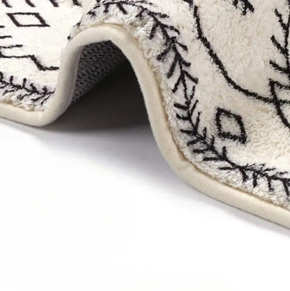 Lange smalle badmat met zwart-wit geometrisch patroon en antislip onderkant.