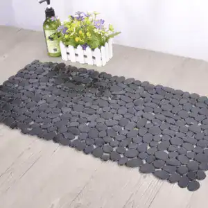 Zwarte rubber badmat met antislip oppervlak, geplaatst op houten vloer in badkamer.