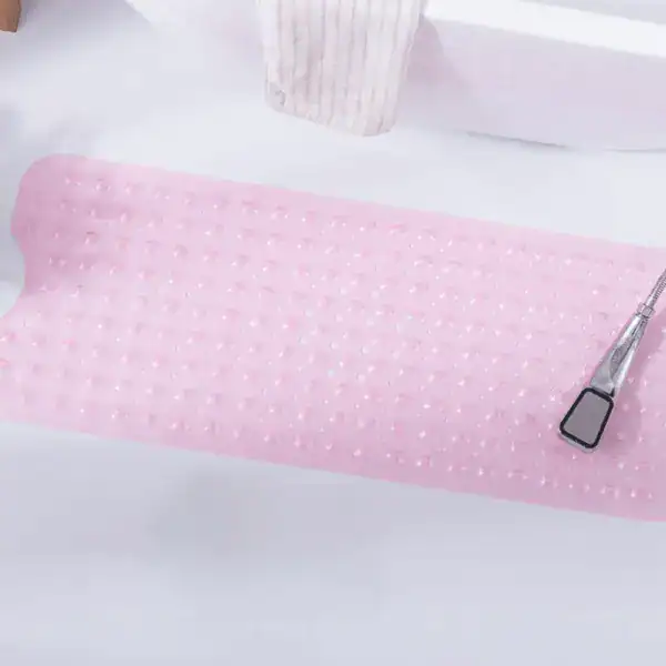 Roze rubberen antislipmat voor bad, met stippenpatroon en douchekop erop.