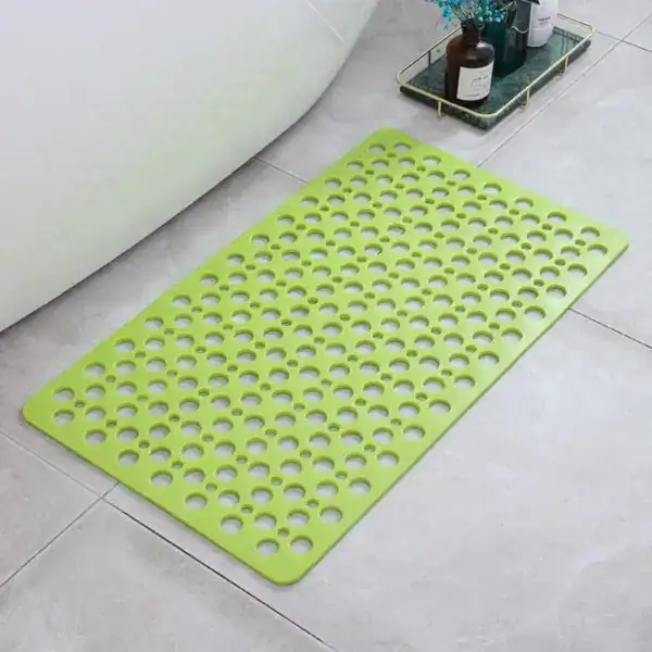 Groene sneldrogende douchemat met gaten voor antislip in badkamer.