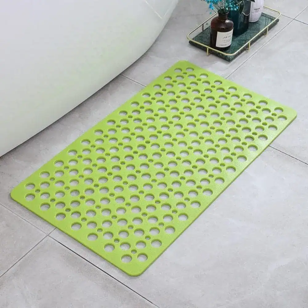 Groene sneldrogende douchemat met gaten voor antislip in badkamer.