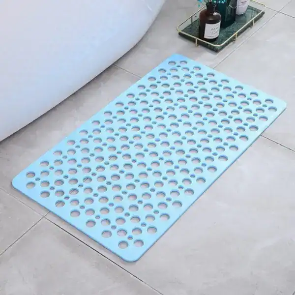 Lichtblauwe sneldrogende douchemat met gaten voor antislip effect in badkamer.