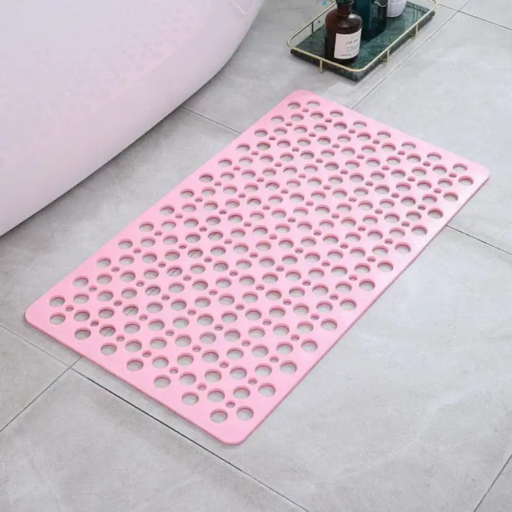 Roze sneldrogende douchemat met gaten voor antislip in badkamer.
