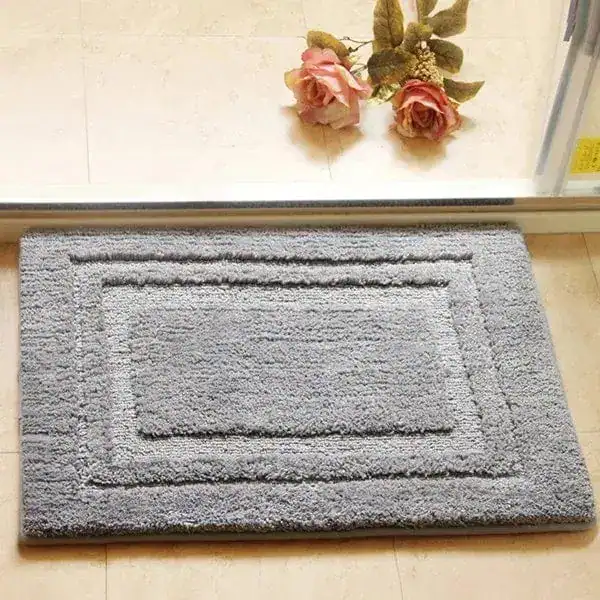 Grijze badmat met gestikt randpatroon, geschikt voor badkamer en douche.