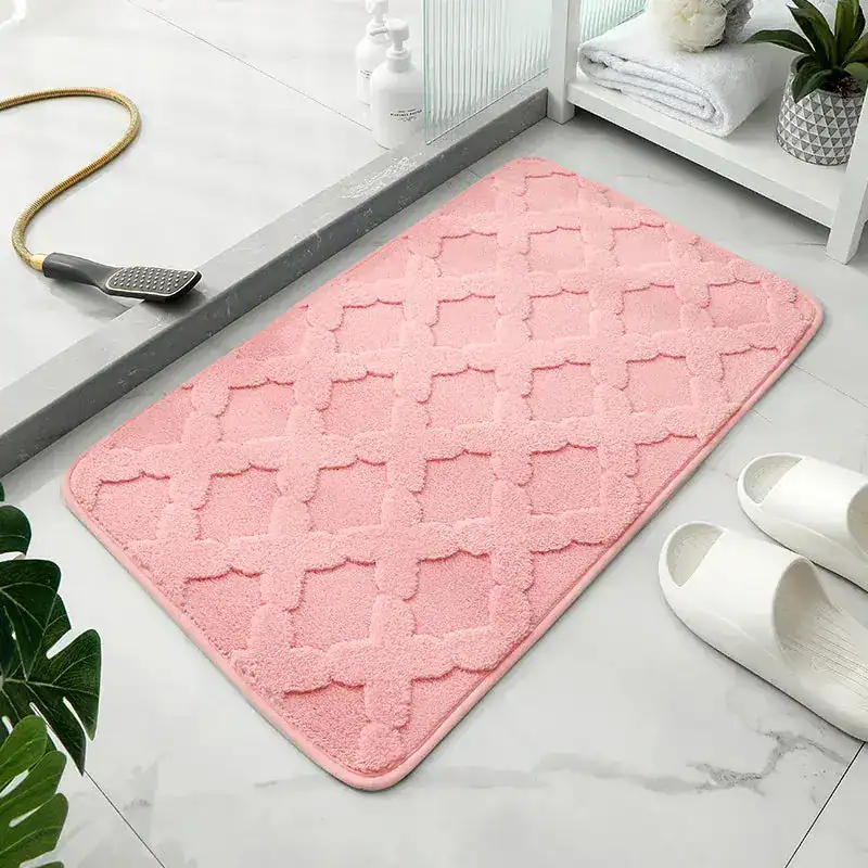 Roze badmat met antislip textuur in de badkamer.