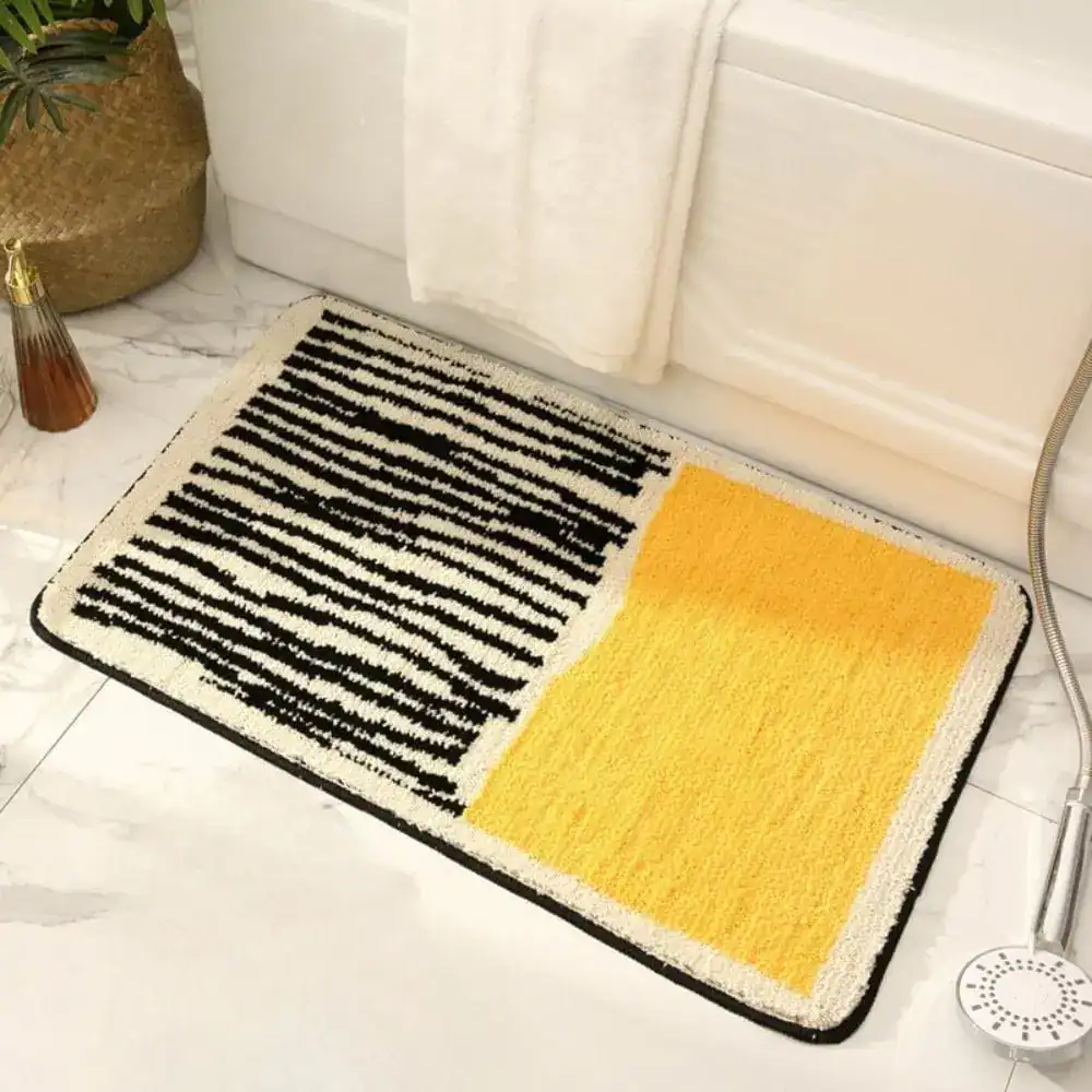 Zwart wit badmat met gele vlek en gestreepte textuur voor badkamer.