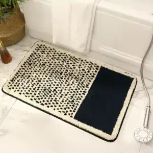 Zwarte en witte badmat met stippenpatroon en antislip rand.